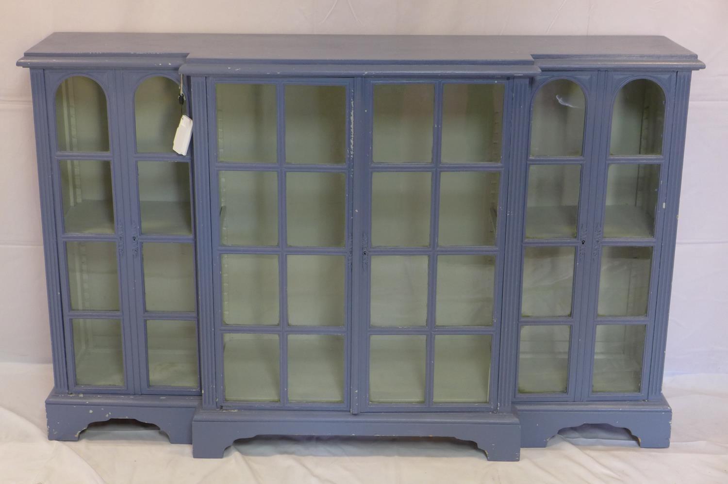 A large blue painted breakfront bookcase, H.101 W.161 D.40cm