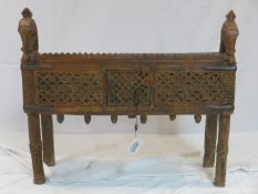 A 20th century Indonesian carved teak side cabinet with horse head finials, H.72 W.82 D.32cm