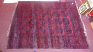 A 20th century Afghan Bokhara carpet, with repeating gull motifs, on a red ground, contained by many