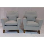 A pair of 20th century armchairs raised on splayed teak feet