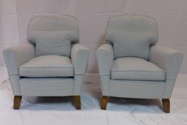 A pair of 20th century armchairs raised on splayed teak feet