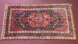 A North West Persian rug, central double pendent medallion with repeating petal motifs on a sapphire