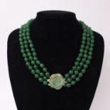 A jade beaded necklace with carved jade flower to silver plated clasp