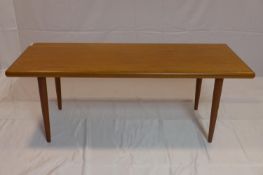 A 20th century teak coffee table raised on tapered legs, H.47 W.131 D.52cm