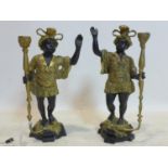 A pair of cast metal Blackamoor candlesticks, in elaborate dress and plumed turbans and holding