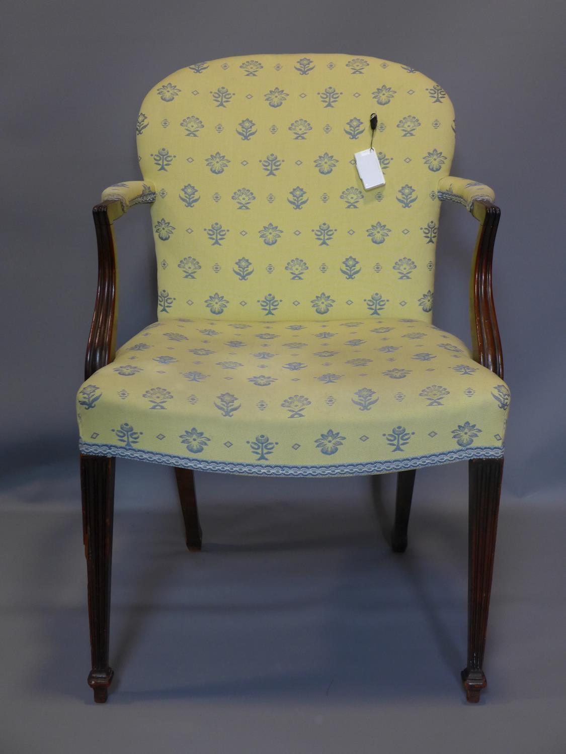 An Edwardian Sheraton Revival armchair with reeded tapering legs