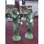 Two cast iron fairies in the verdigris finish, one holding a bird, H.52cm, the other holding a