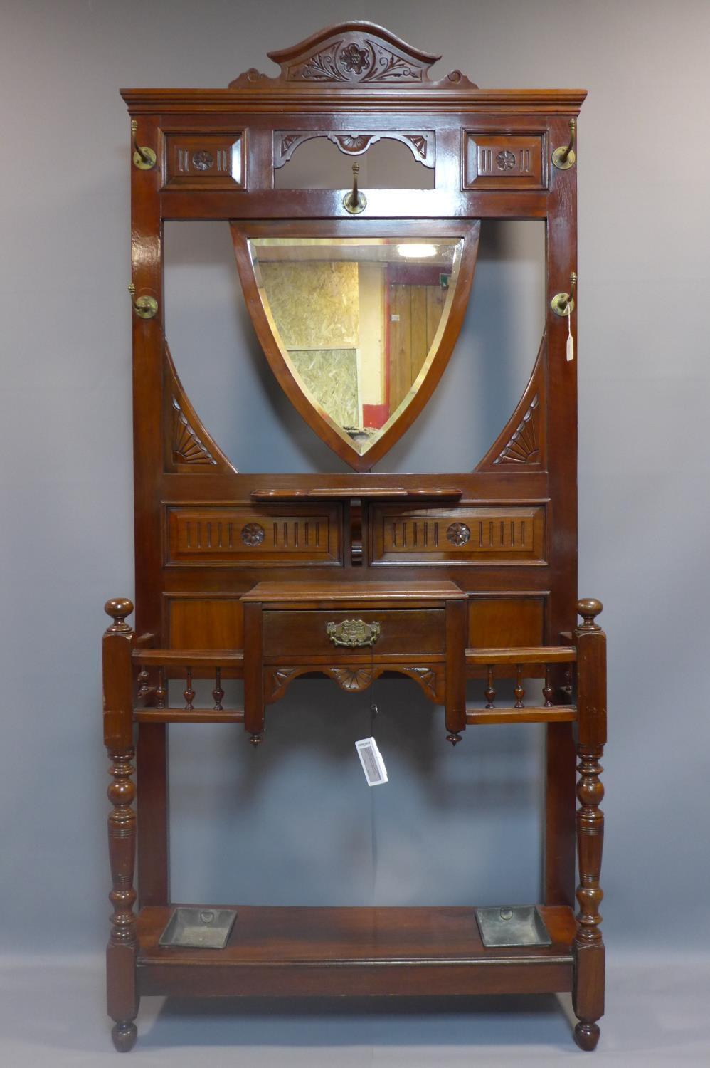 A Victorian Aesthetic mahogany hallstand, having shield mirror with bevelled plate, with single