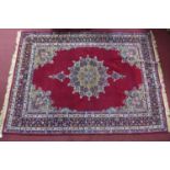 An antique Kirman rug with floral medallion, on a red ground, contained by floral border, 213 x