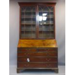 A Georgian style bureau bookcase, with two astragal glazed doors above bureau and an arrangement