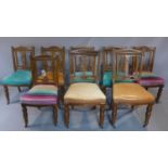 A set of Eight late 19th century oak dining chairs with carved back rests, all upholstered in 3