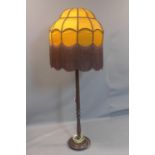 A vintage standard lamp with large orange shade with tassels, on turned support, H.175cm