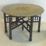 A 20th century Moroccan tea table, with brass tray top on folding base, H.50 D.78cm