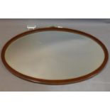 A 19th century oval inlaid mahogany wall mirror, with bevelled glass plate, 59 x 94cm
