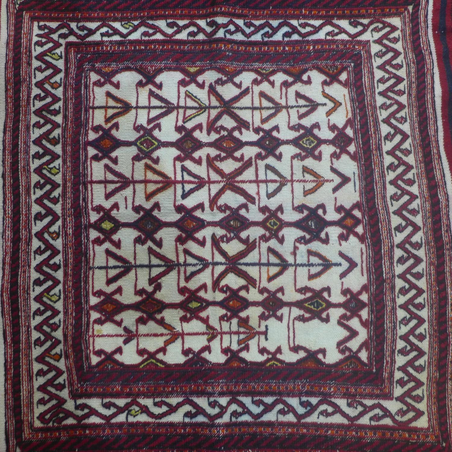 A north east Persian Sumak kelim with repeating stylised geometric motifs on a rouge field. L.120 - Image 2 of 4