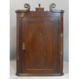 A Georgian mahogany corner cupboard with arched neck pediment. H.107 W.74cm