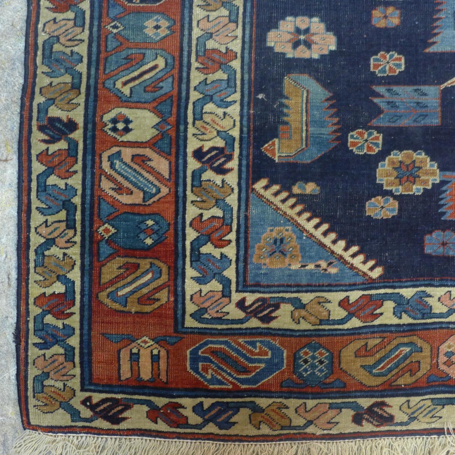 A Caucasian rug with geometric and floral motifs on a dark blue ground, within stylised floral - Image 4 of 5