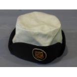 A Naval Nurse's service cap, the label to interior stating 'Caps Service Naval Nurse - S - Nato