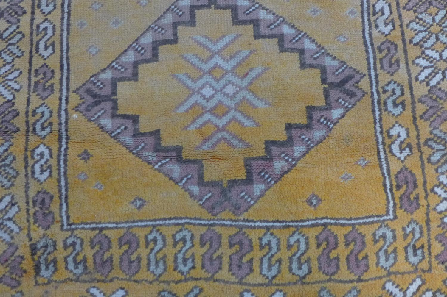 A Moroccan rug, with triple diamond pole medallions on an orange ground, within stylised floral - Image 3 of 5