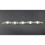 An antique white metal and pearl set bracelet