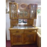 An Arts & Crafts walnut cabinet with 3 bevel glass cupboard doors above bevelled mirror and marble