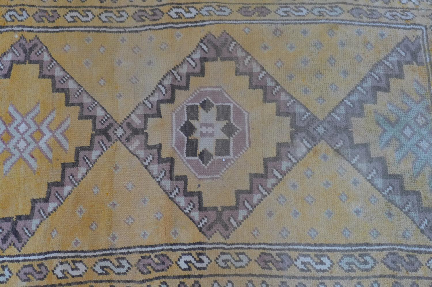 A Moroccan rug, with triple diamond pole medallions on an orange ground, within stylised floral - Image 2 of 5