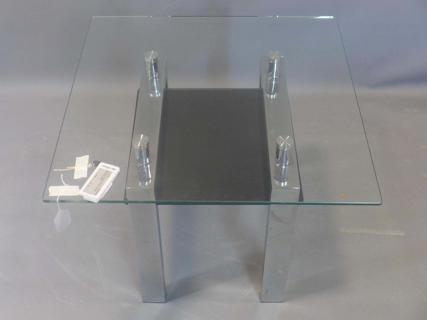 A contemporary chrome and glass side table, with black tempered glass undertier, H.50 W.65 D.65cm