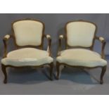 A pair of French style open armed walnut framed fauteuil. H.79cm