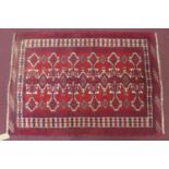 A north east Persian Yamut rug, the repeating stylised goul motifs on a rouge field within