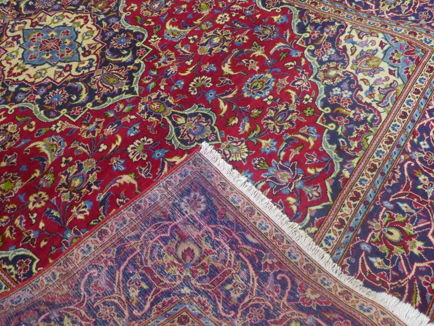 a central Persian Kashan carpet, the central double medallion with repeating petal motifs on a rouge - Image 5 of 5