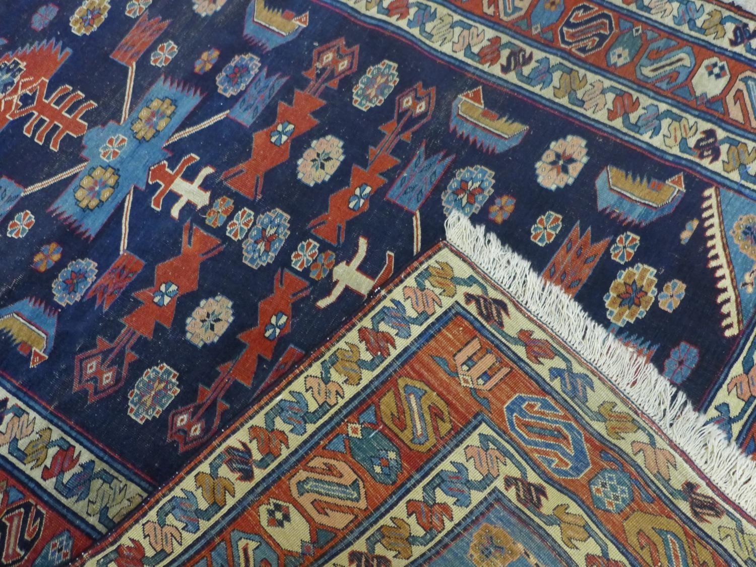 A Caucasian rug with geometric and floral motifs on a dark blue ground, within stylised floral - Image 5 of 5