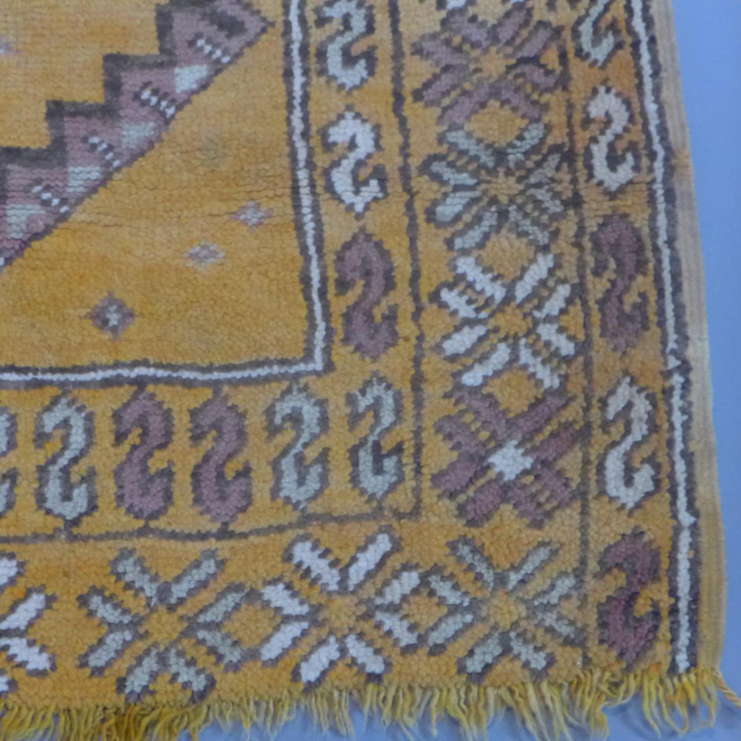 A Moroccan rug, with triple diamond pole medallions on an orange ground, within stylised floral - Image 4 of 5