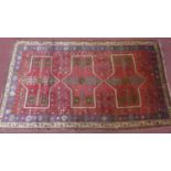 A north east Persian Kurdie carpet with triple pole medallion and repeating petal motifs on a