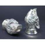 A pair of silver plated condiments in the form of textured boars heads each with faceted ruby