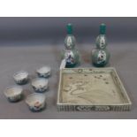 A pair of boxed Japanese sake flasks with cups and a boxed square dish.