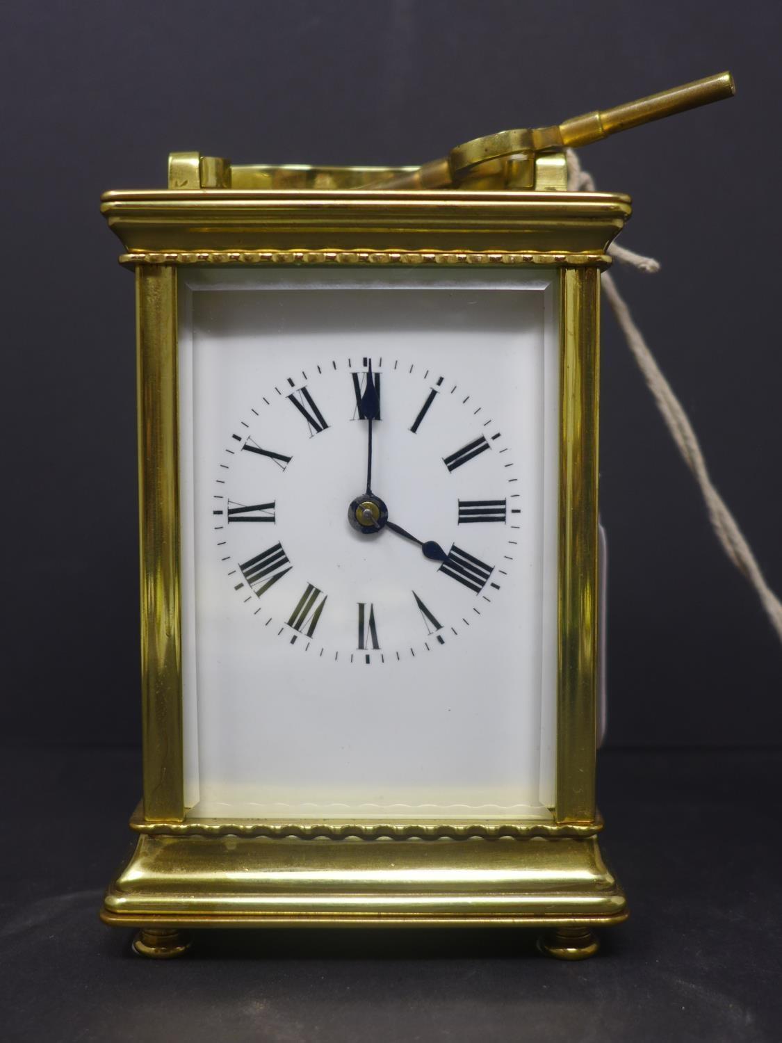 A 20th century French gilt brass carriage clock, the enamel dial with Roman numerals, having key,