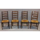 A set of four ladder back dining chairs, with rush seats, on ball feet