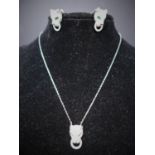 A boxed sterling silver and white crystal suite, comprising of leopard head earrings and pendant