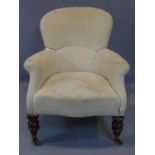 A low armchair, marked Howard & Sons, raised on turned mahogany legs and castors, H.84cm, needs