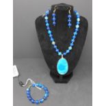 A gold plated and blue agate jewellery suite, to include a blue agate beaded necklace with oval blue