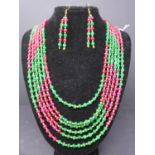A ruby and emerald six strand beaded necklace, together with a pair of matching two stand beaded