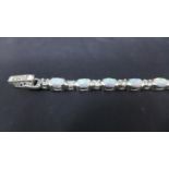 A sterling silver bracelet alternately set with oval opalites and faceted white crystals, L: 18.5cm,