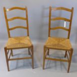 A pair of oak ladderback chairs with rush seats