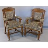 A pair of Victorian oak armchairs, on turned supports joined by stretcher, raised on castors