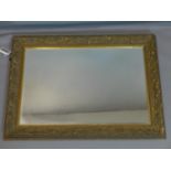 A giltwood mirror with floral border and bevelled plate, 78 x 100cm