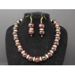A beaded garnet, gold plated and cubic zirconia set necklace and matching pair of earrings