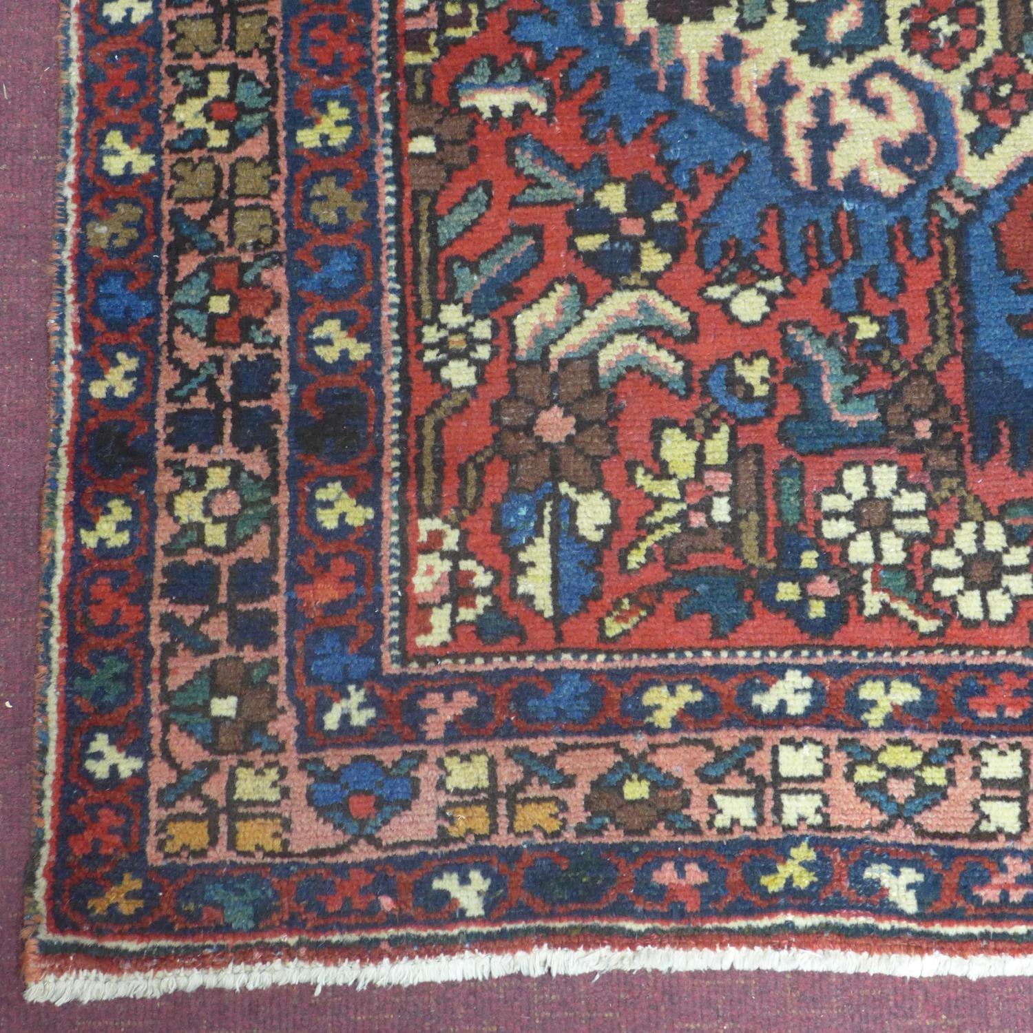 A Central Persian Bakhtiari rug, repeating stylised floral motifs on an ivory field, within stylised - Image 4 of 5