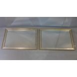 A pair of contemporary wall mirrors, with silver painted frames and bevelled glass plates, 87 x 61cm