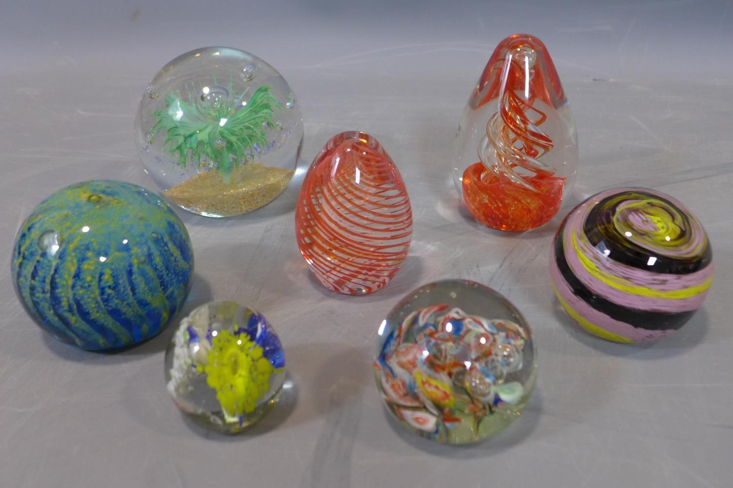 A collection of glass paperweights, to include a fish-shaped turquoise and white paperweight; a