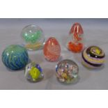 A collection of glass paperweights, to include a fish-shaped turquoise and white paperweight; a